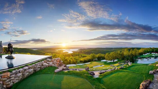 A golf course with a stone bridge, a statue, and a building in the background. - SPACIOUS GOLF Course view & close to Strip, Lake & SDC! BEST LOCATION in town!  (Branson)
