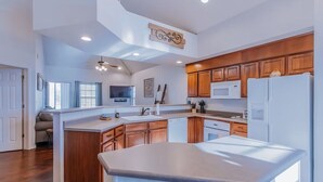 A modern kitchen with wooden cabinets, a central island, and built-in appliances. - SPACIOUS GOLF Course view & close to Strip, Lake & SDC! BEST LOCATION in town!  (Branson)