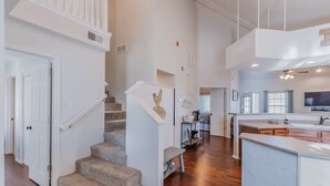 A spacious living area with a staircase, a kitchen with a large island, and a dining area. - SPACIOUS GOLF Course view & close to Strip, Lake & SDC! BEST LOCATION in town!  (Branson)