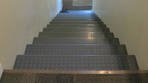 A staircase with a handrail, carpeted steps, and a window at the top. - Elite 2-bedroom apartment in Moose Creek with WiFi (North Pole)