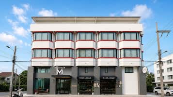 A multi-story building with a modern design, featuring a prominent 'BOUTIQUE' sign and 'VI CAFE x SOLBAR' signage.