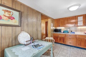 A kitchen with wooden cabinets, a microwave, and a table with a clock and magazines. - Secluded Colorado Ranch on 140 Acres Near Salida (Cotopaxi)
