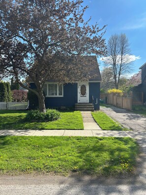 Une maison d’habitation avec un jardin devant, une allée et une boîte aux lettres.