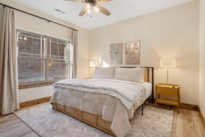 A bedroom with a bed, a window, a ceiling fan, and a bedside table with a lamp. - Private Hot Tub Cabin at Tall Timbers, Water View, Bunk Room, Community Pools & Free Ticket (Hollister)