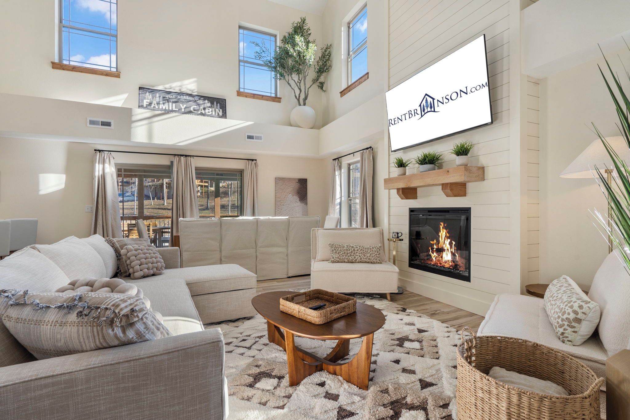 A spacious living room with a fireplace, comfortable seating, and a large window providing natural light.