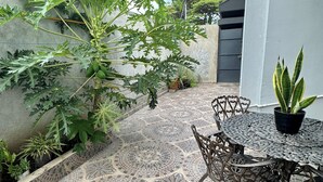 A patio with a mosaic tile floor, a metal table with chairs, and a potted plant. - Charming 3-bedroom apartment with WiFi, AC and a picuzzy in Santo Domingo Oeste. (Santo Domingo Oeste)
