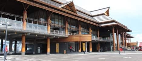 A modern building with a flat roof, large windows, and a covered entrance area.