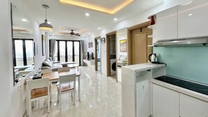 Une chambre d’hôtel moderne dotée d’un coin repas, d’une cuisine et d’un balcon avec vue.