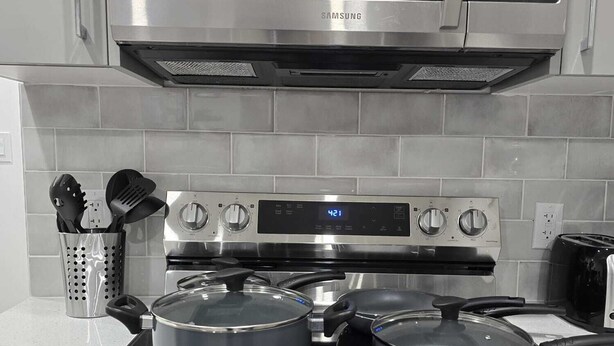 Une cuisine équipée d’un four à micro-ondes, d’un four et d’une cuisinière en acier inoxydable.