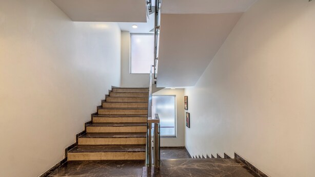 A modern staircase with a metal railing, leading to a door at the top. - Treebo D Consulate Hitech City (Hyderabad)