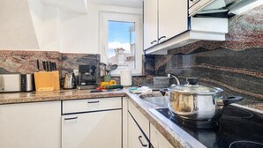 Eine moderne Küche mit einer Granit-Arbeitsplatte, Edelstahlgeräten und Blick ins Freie.