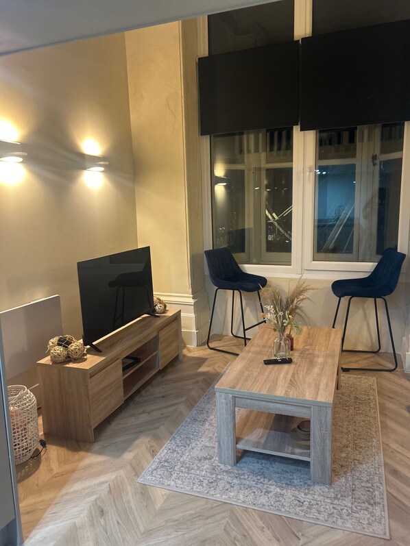 Relax in this stylish living room with a large flat-screen TV, comfortable seating, and a beautiful rug.