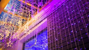 A building facade with a grid-like pattern of lights and hanging decorations. - Artinn Kaifeng hotel (Taipei)