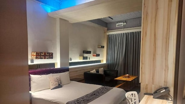 A modern hotel room with a bed, a desk, and a small seating area. - Artinn Kaifeng hotel (Taipei)