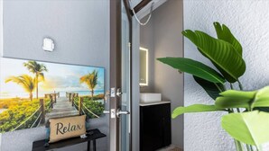 A bathroom with a wooden door, a sink, and a towel rack.