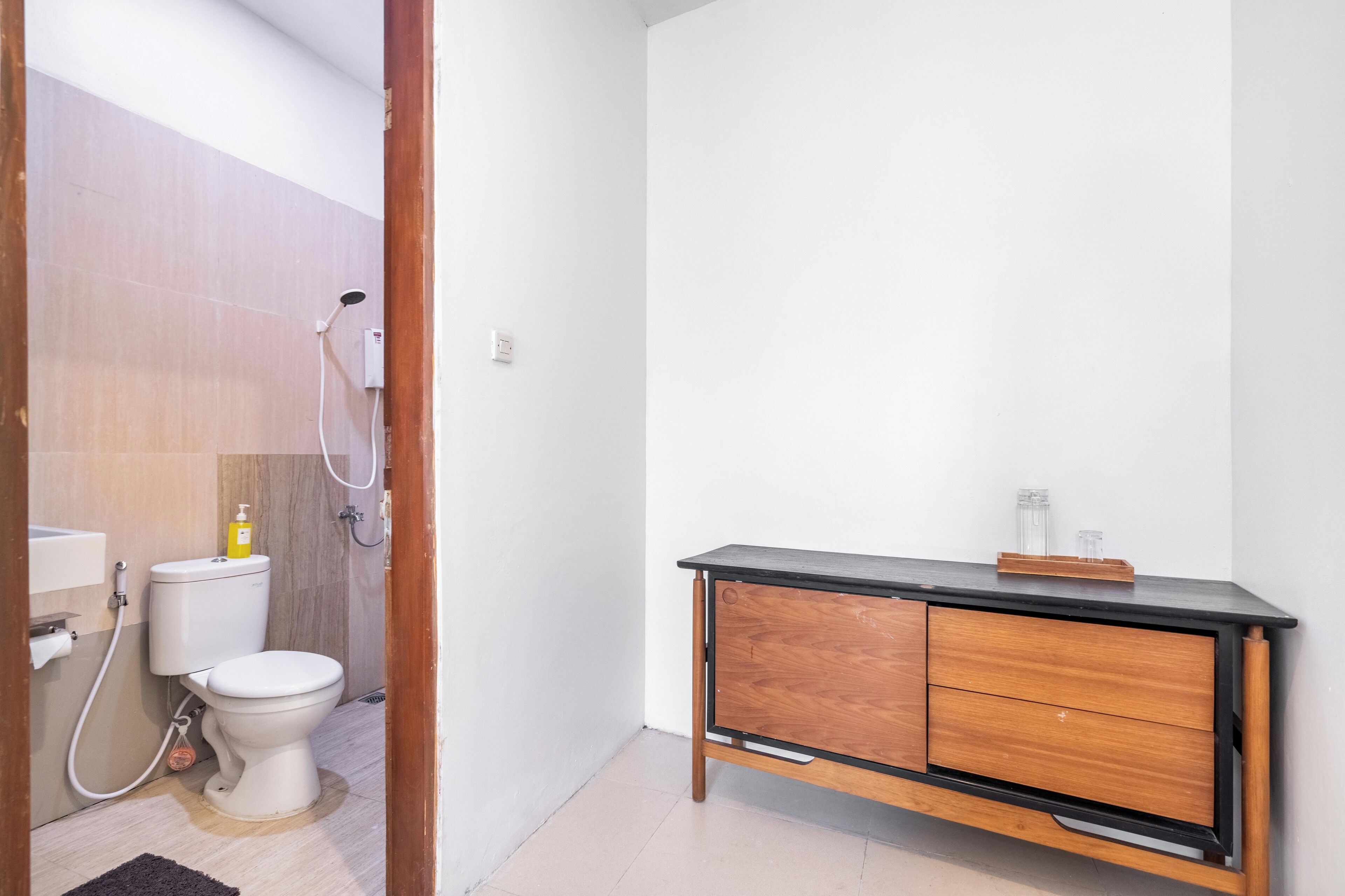 Une salle de bain équipée de toilettes, d’une douche et d’un meuble en bois avec des tiroirs.