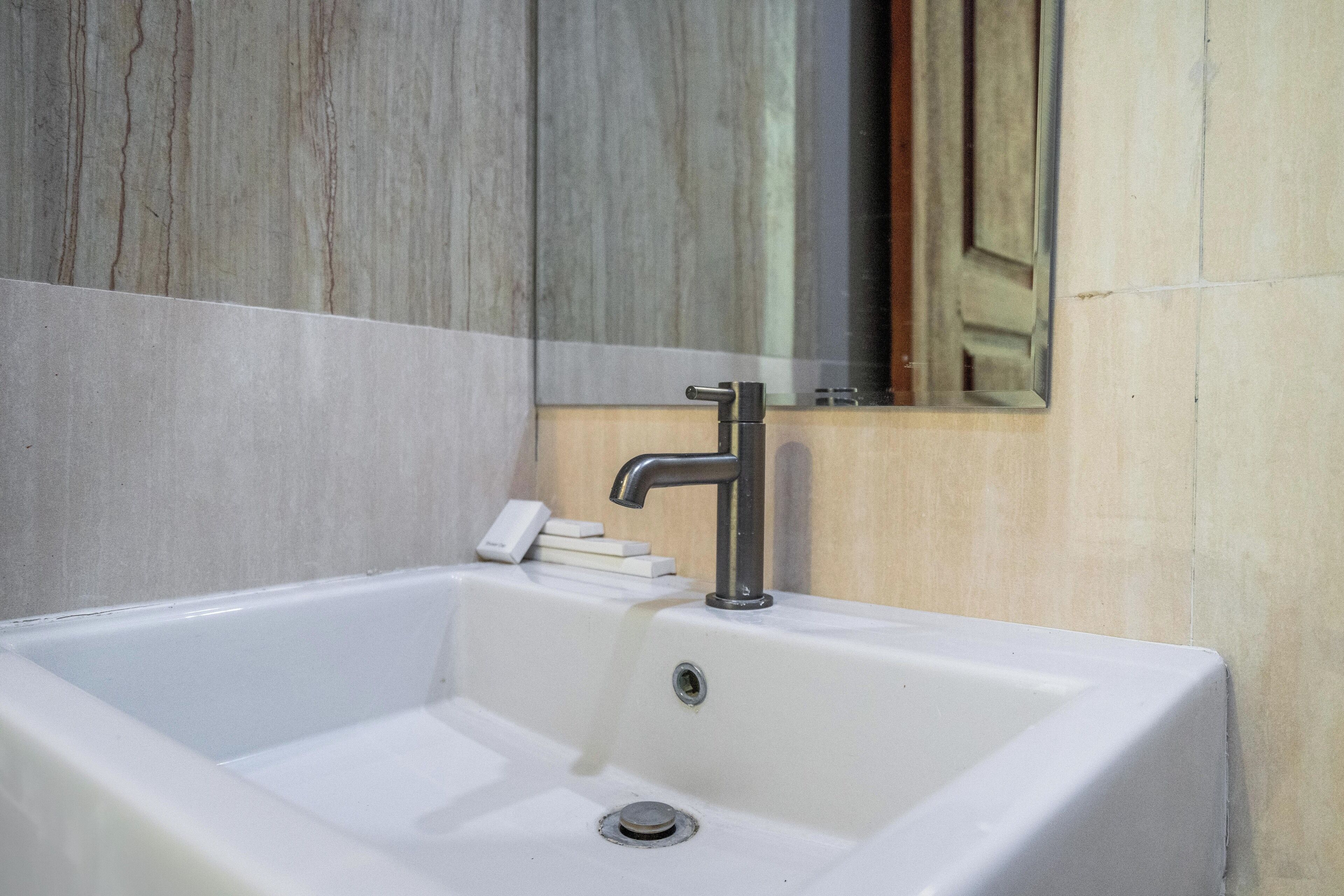 Une salle de bain avec un lavabo blanc, un miroir et un meuble en bois.