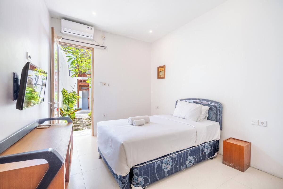 Una habitación de hotel con cama, escritorio y televisor.