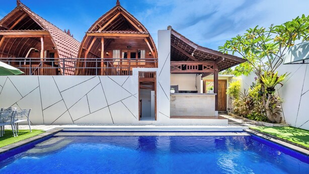 Un edificio moderno con piscina, estructuras de madera y jardín.
