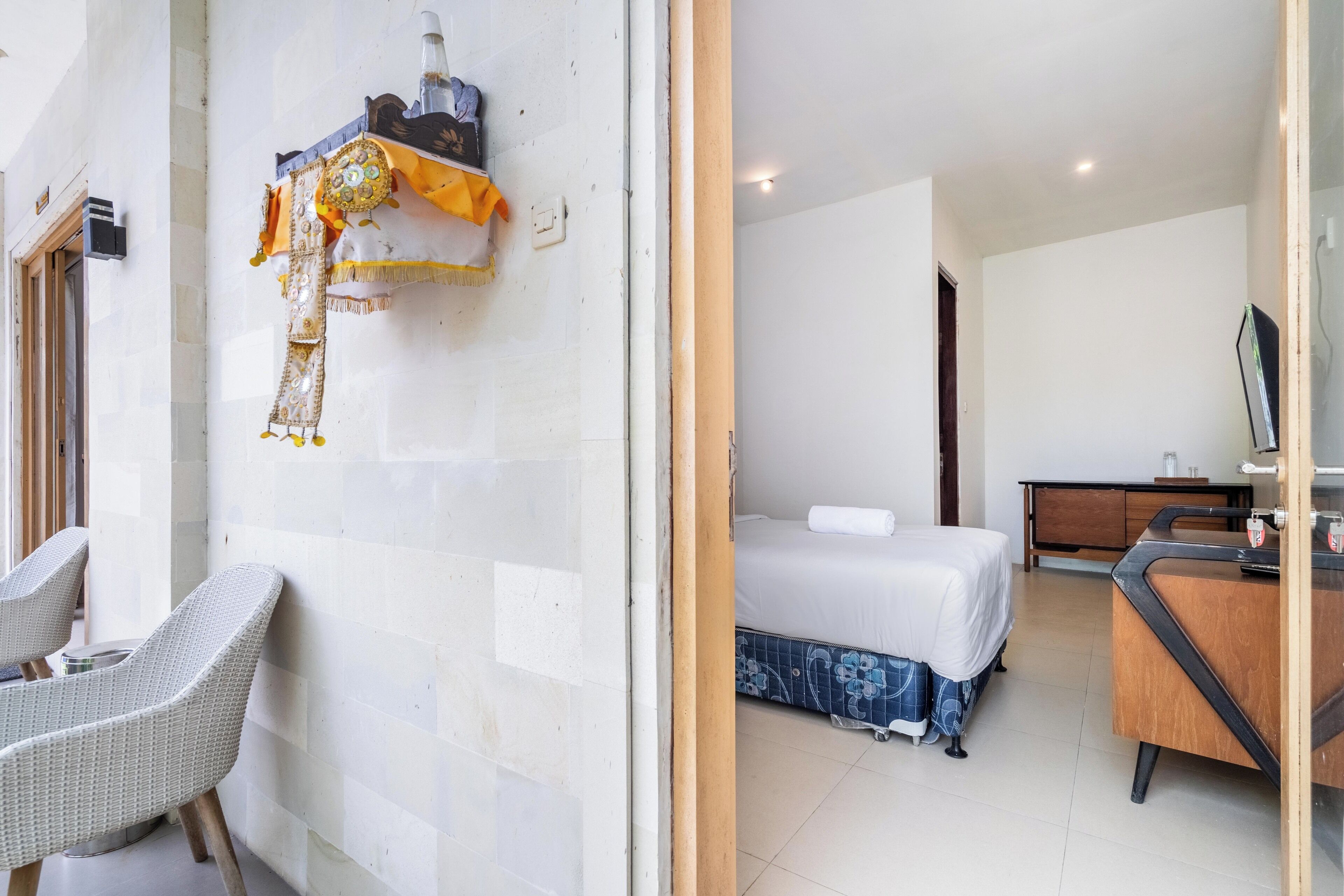 A hotel room with a bed, a desk, and a chair.