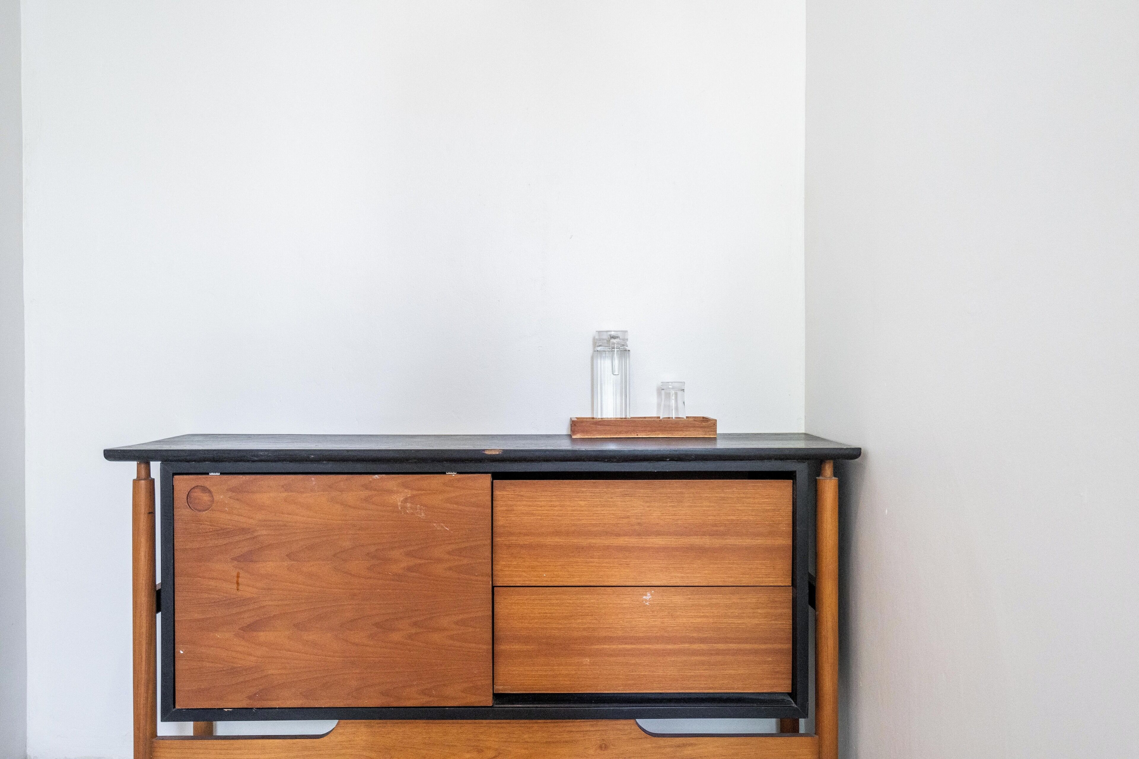 A wooden desk with a black top and a single drawer.