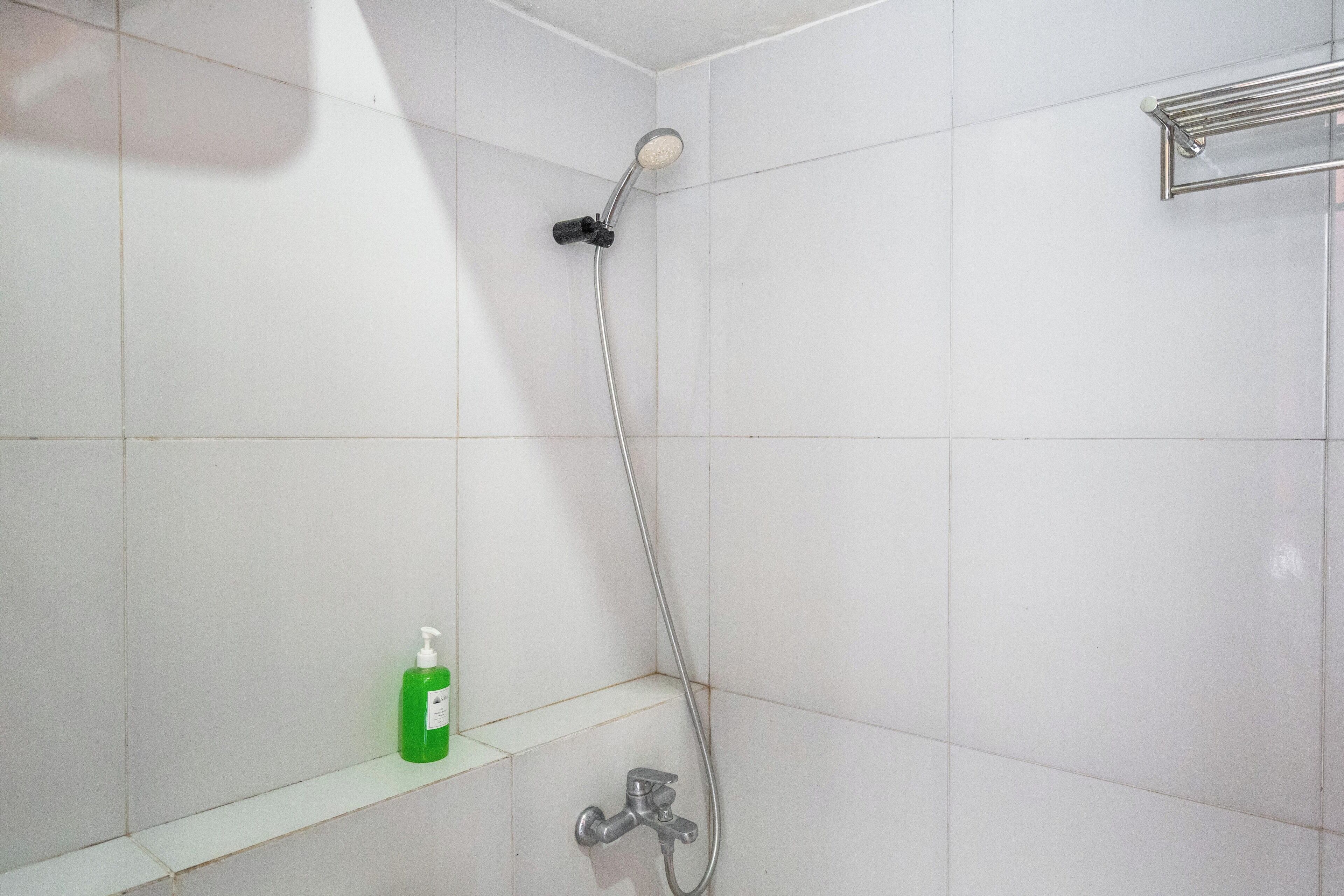 Ducha con cabezal de ducha de mano y grifo empotrado.