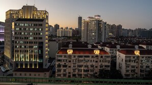 Un paisaje urbano con edificios altos, algunos con ventanas iluminadas, y una variedad de estilos arquitectónicos.