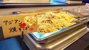 A buffet with a sign indicating a noodle dish, possibly with chicken and vegetables.