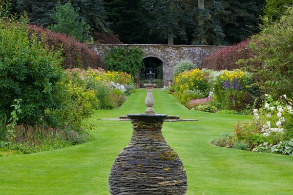 Stables Cottage - a pristine lawned walk and diverse flowers in Kailzie Gardens, the mature trees of the woodland lying beyond the wall