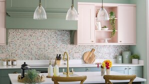 A kitchen with a central island, two bar stools, pendant lights, and a backsplash with floral patterns. - Stables Cottage, Kailzie - sleeping 2 guests in one bedroom (Peebles)