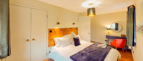 Habitación de hotel con cama, escritorio, silla y baño.