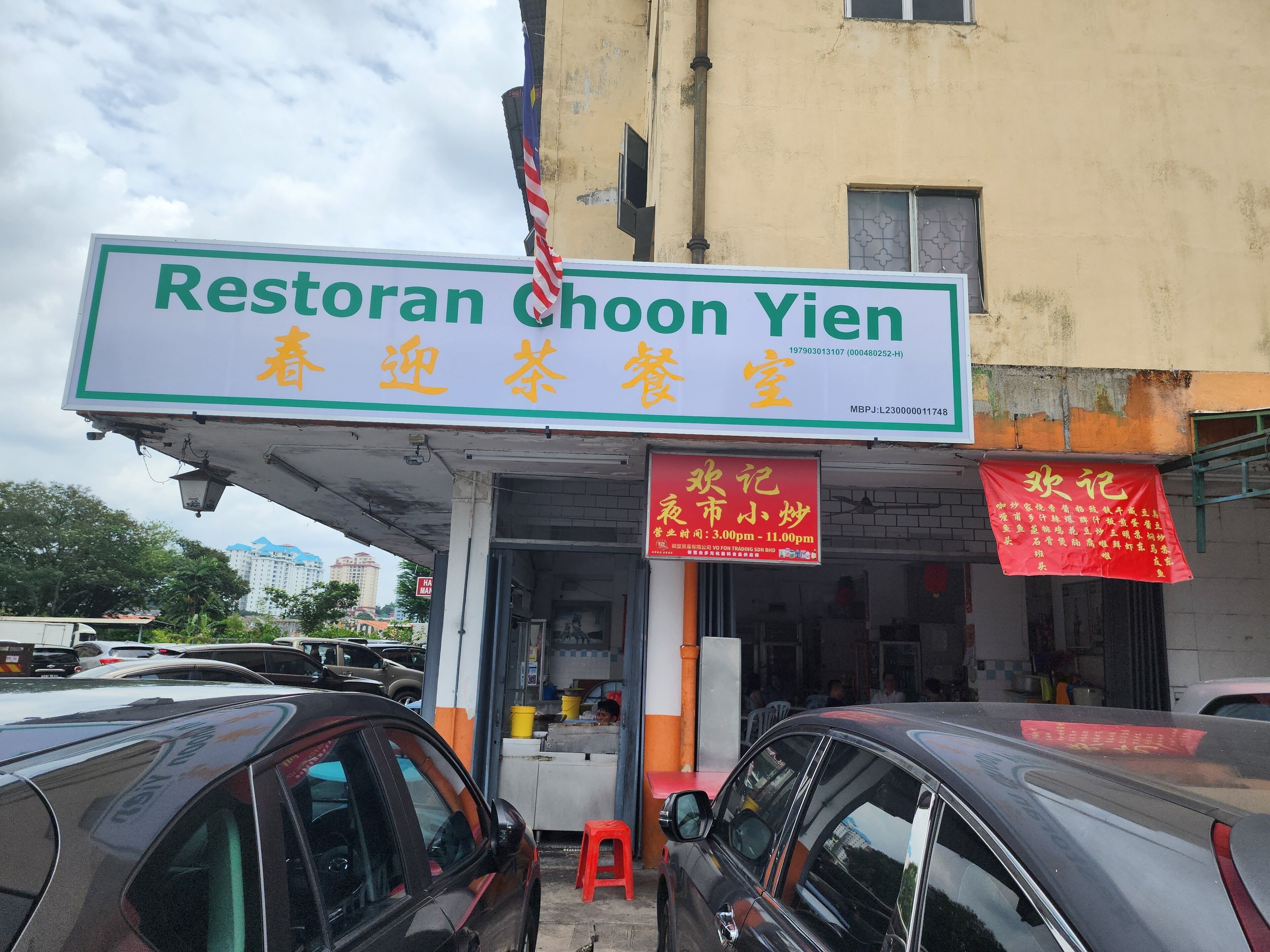A restaurant named Restoran Choon Yien with a signboard displaying its name and contact number.