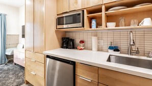 Een moderne keuken met houten kasten, een roestvrijstalen vaatwasser, een magnetron en een spoelbak met kraan.