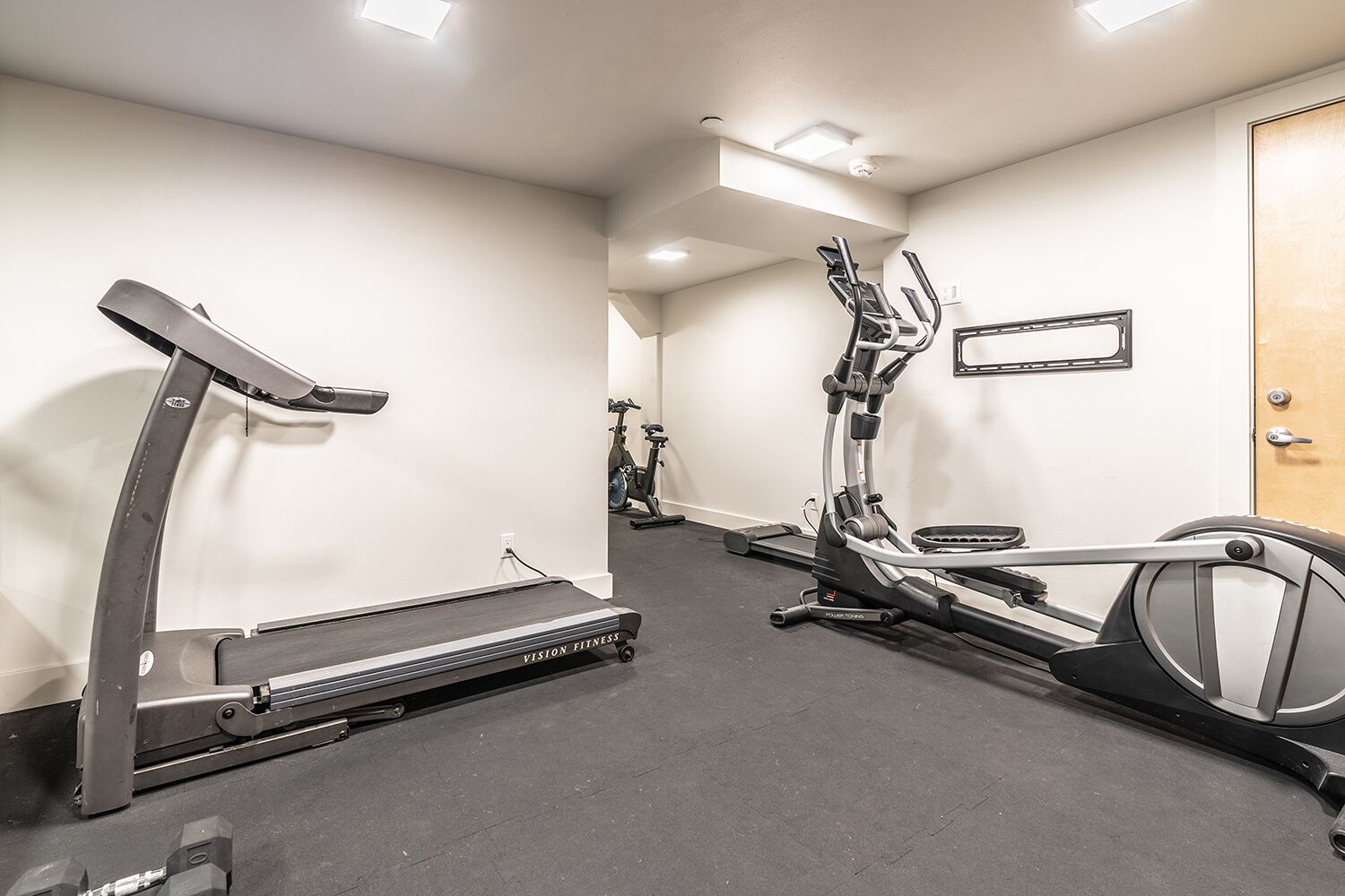 Ein Fitnessraum mit Laufbändern, Ergometer und Crosstrainern.