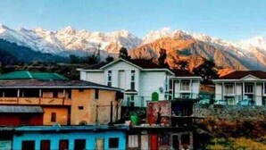 A cluster of buildings with a mountainous backdrop. - Shri Narayan Tourist Lodge (Ukhimath)