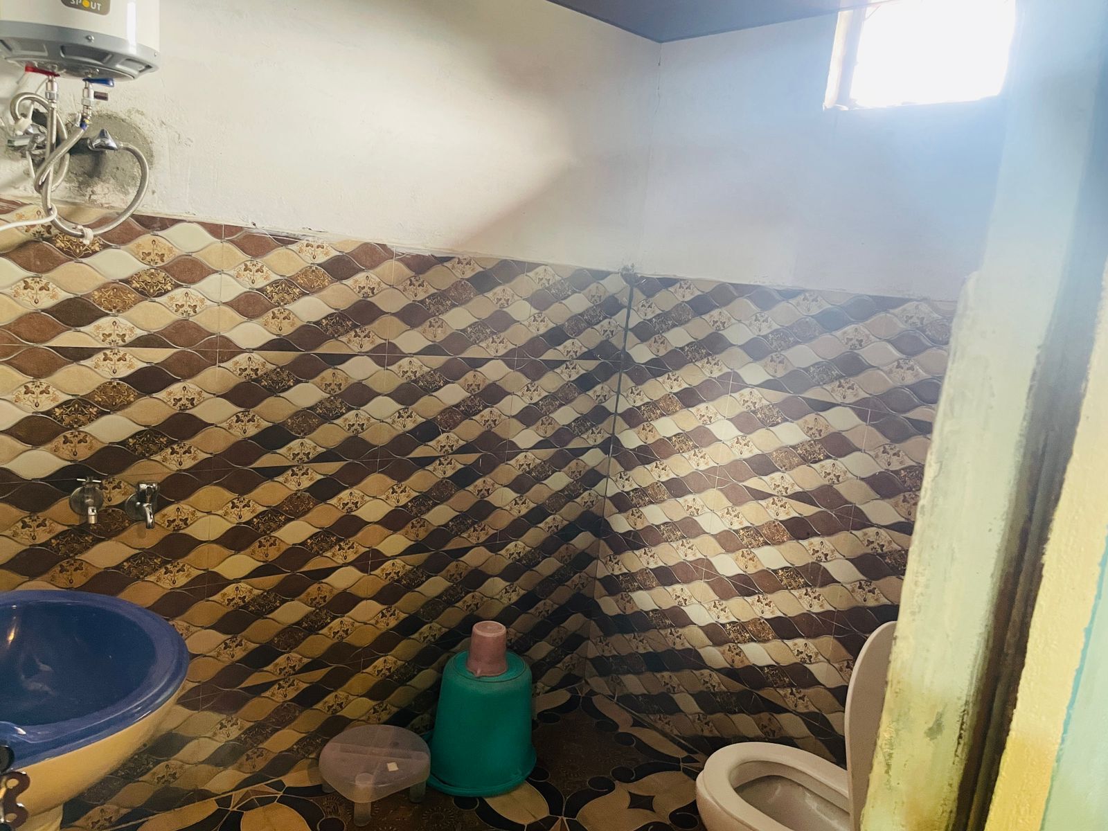 A bathroom with a checkered tile pattern, a sink, a toilet, and a shower.