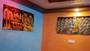A room with a bed, a wall mural, and a ceiling design. - Shri Narayan Tourist Lodge (Ukhimath)