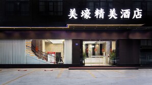 A hotel entrance with a modern facade, a staircase leading to the entrance, and a visible reception area. - Meihao Exquisite Hotel (Guangzhou)
