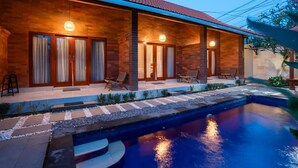 A modern house with a swimming pool, wooden exterior, and outdoor seating. - Comfortable Private Room in Canggu with High-speed WiFi (Bali)