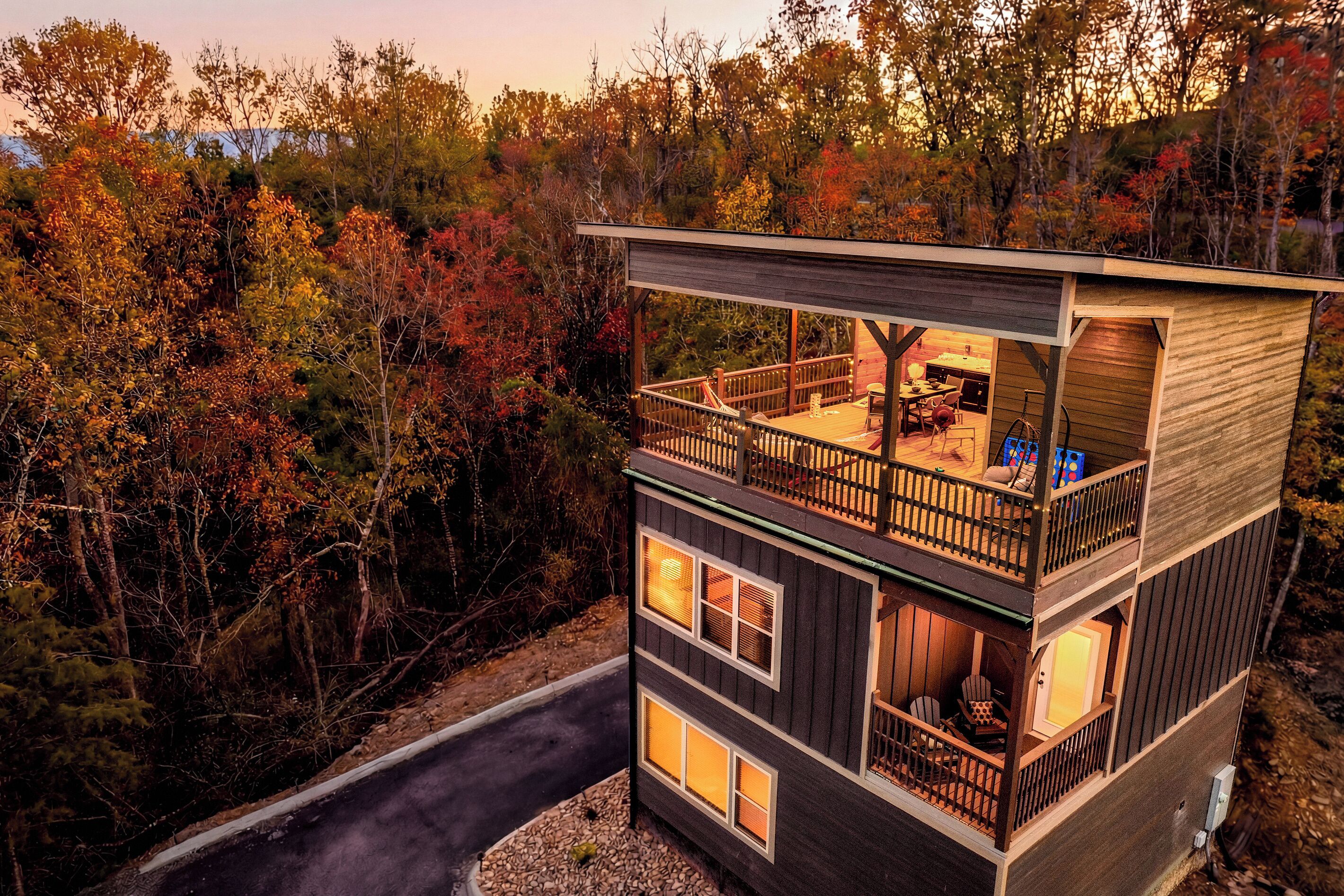 Une cabane à deux étages dotée d’un balcon, entourée du feuillage automnal.