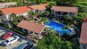 A residential complex with multiple houses, a swimming pool, and a parking area.