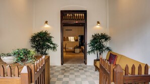 A hallway with a checkered floor, wooden railings, and potted plants on either side. - 8 Leyn Baan Street (Galle)