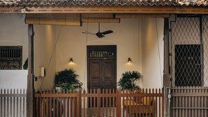 A traditional house with a wooden door, two potted plants, a ceiling fan, and a white picket fence. - 8 Leyn Baan Street (Galle)