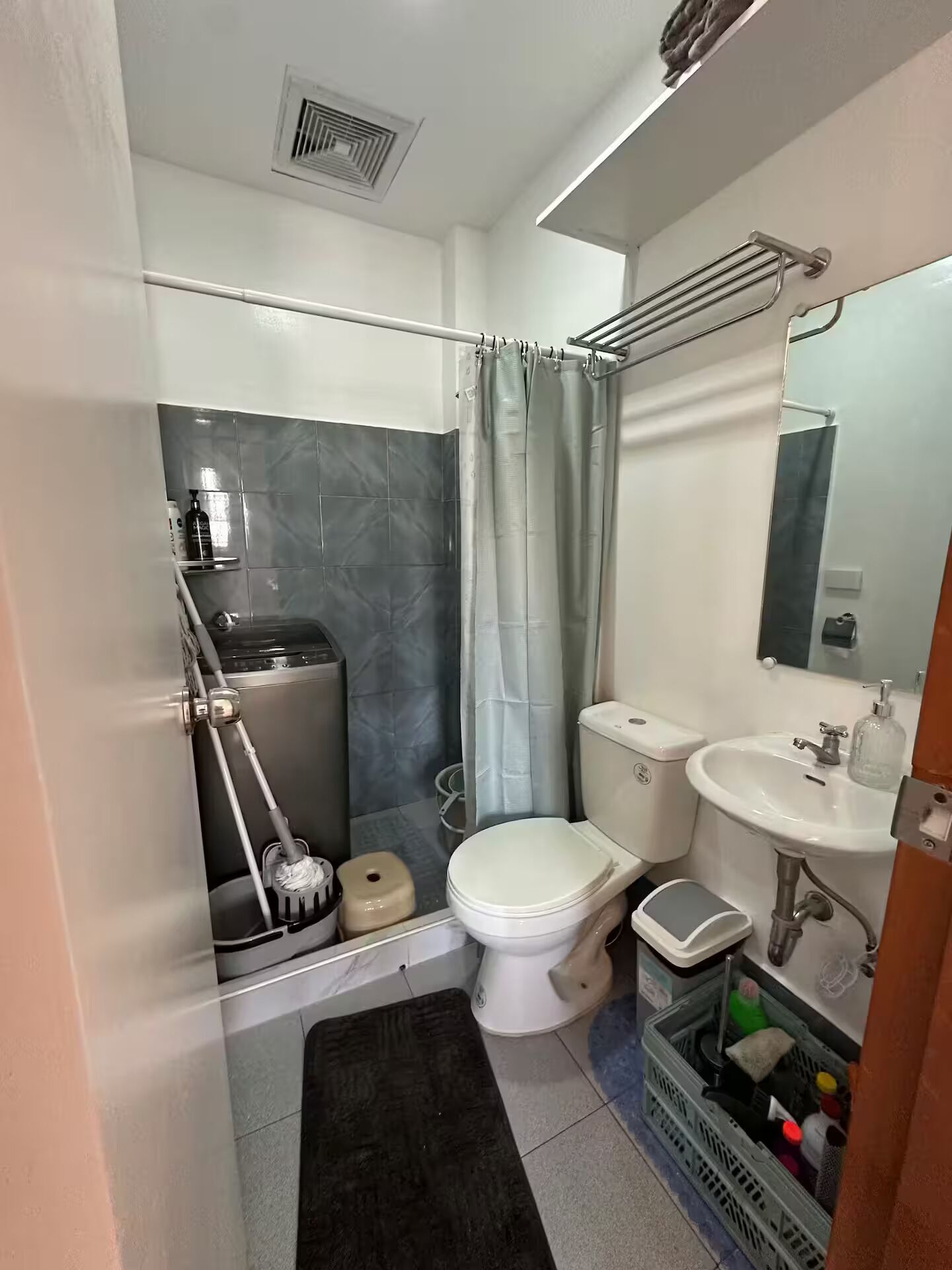 A compact bathroom with a toilet, sink, and shower area.