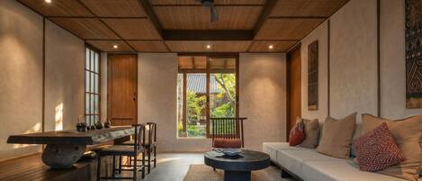 A modern interior with a dining table, sofa, and ceiling fan.