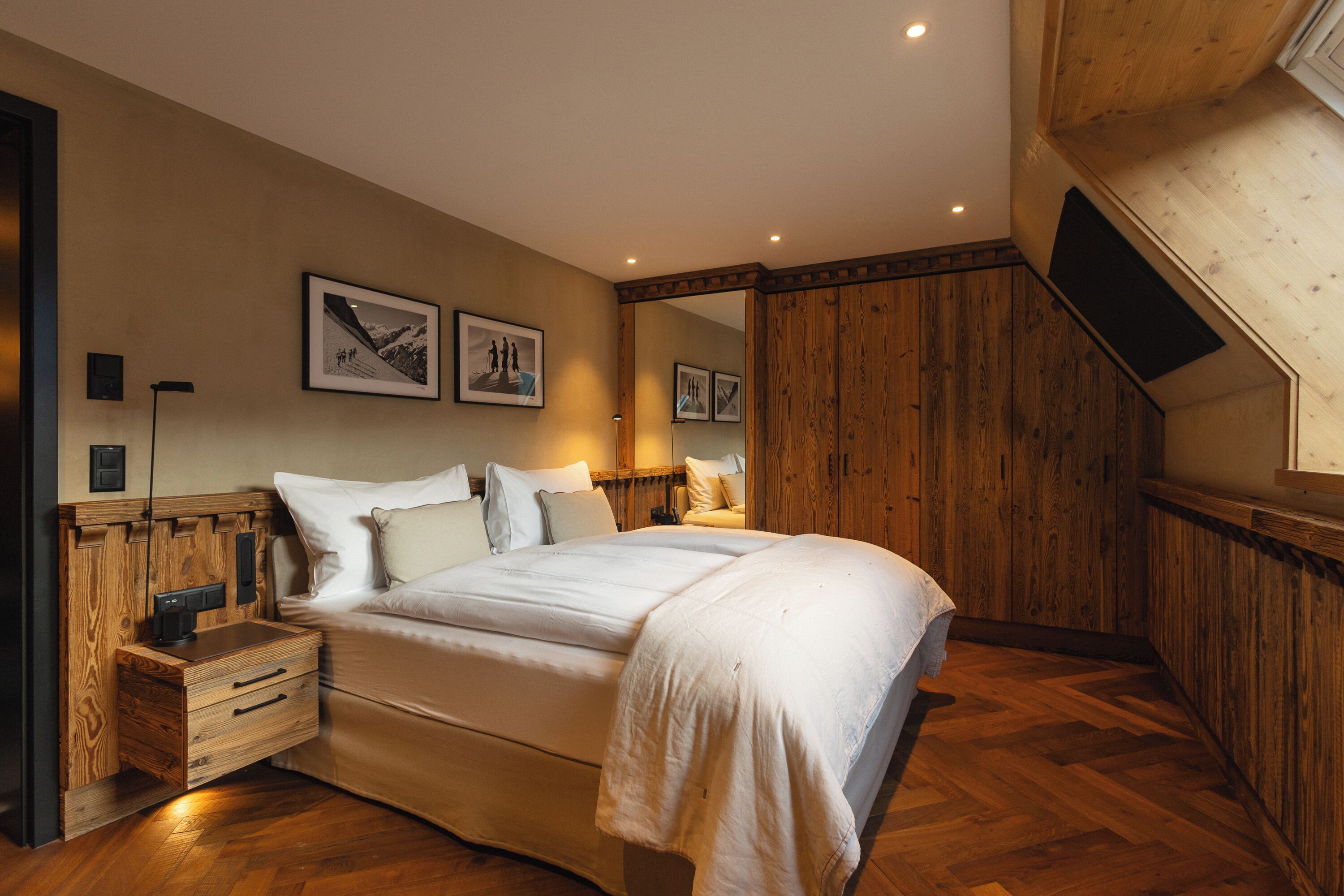 Una camera da letto con una testiera in legno, un letto grande, un comodino e uno specchio a parete.