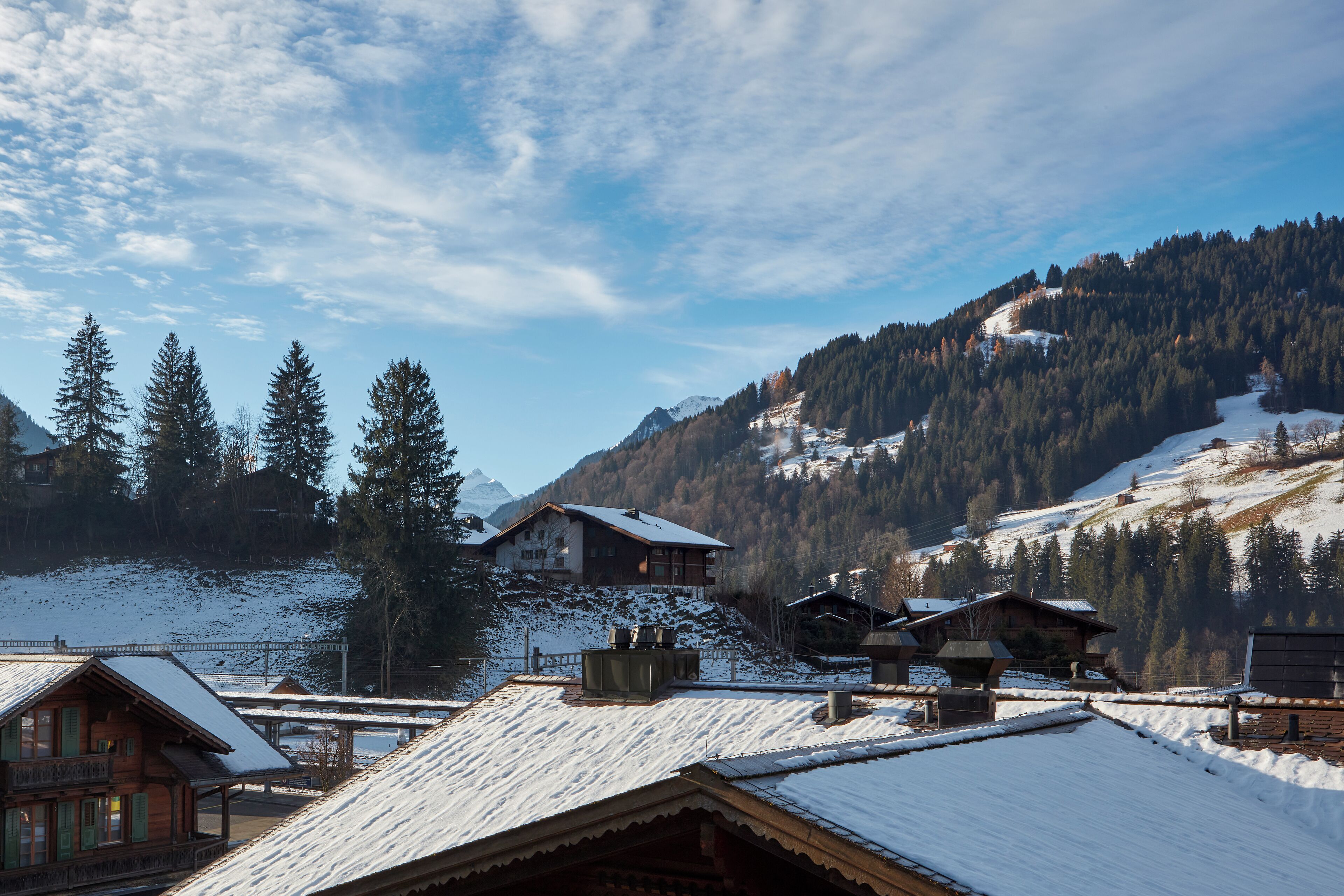 A snow-covered mountain village with wooden buildings and a clear sky.