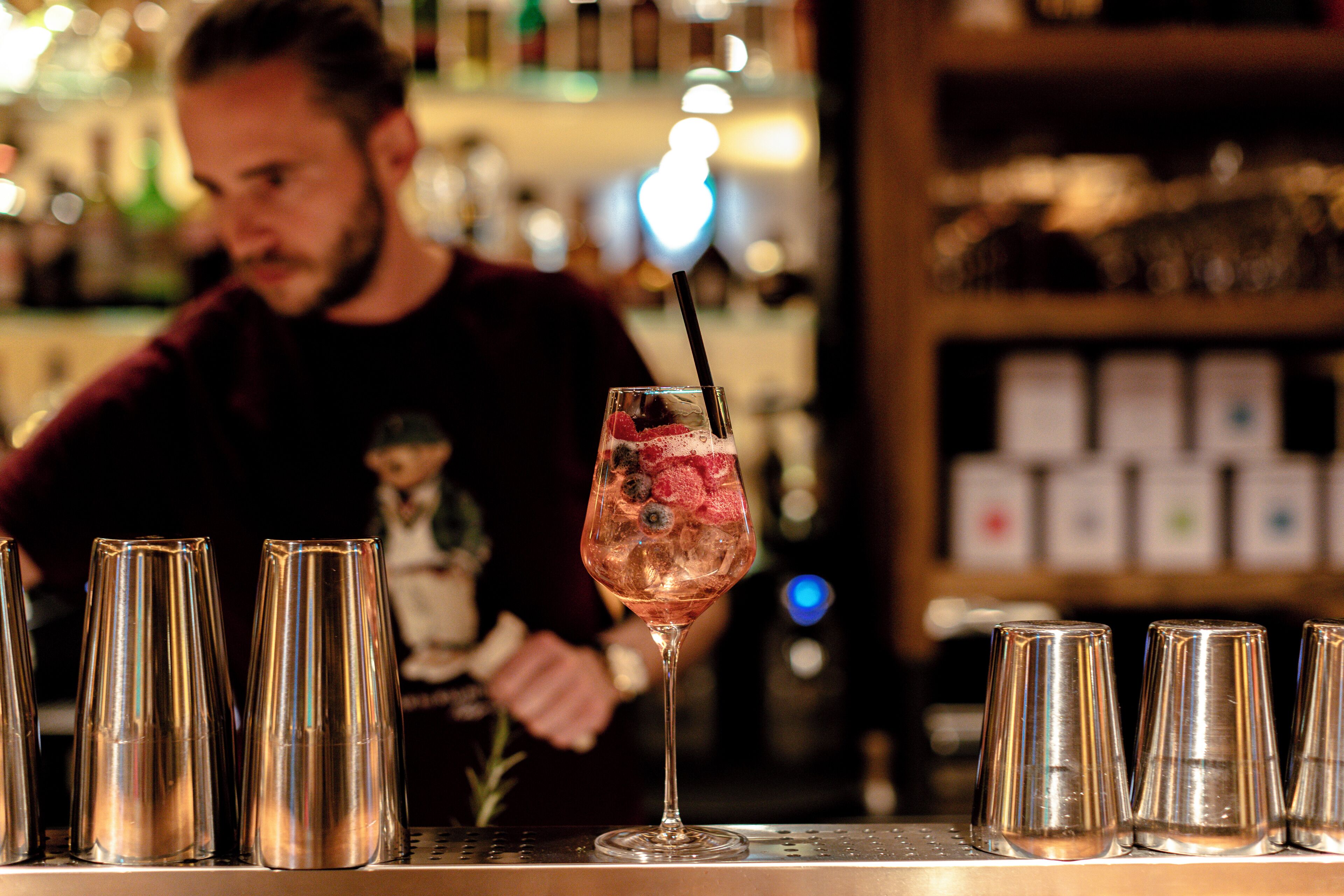 Eine Bar mit einem Cocktailglas und mehreren leeren Gläsern auf der Theke.