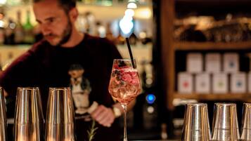 Eine Bar mit einem Cocktailglas und mehreren leeren Gläsern auf der Theke.