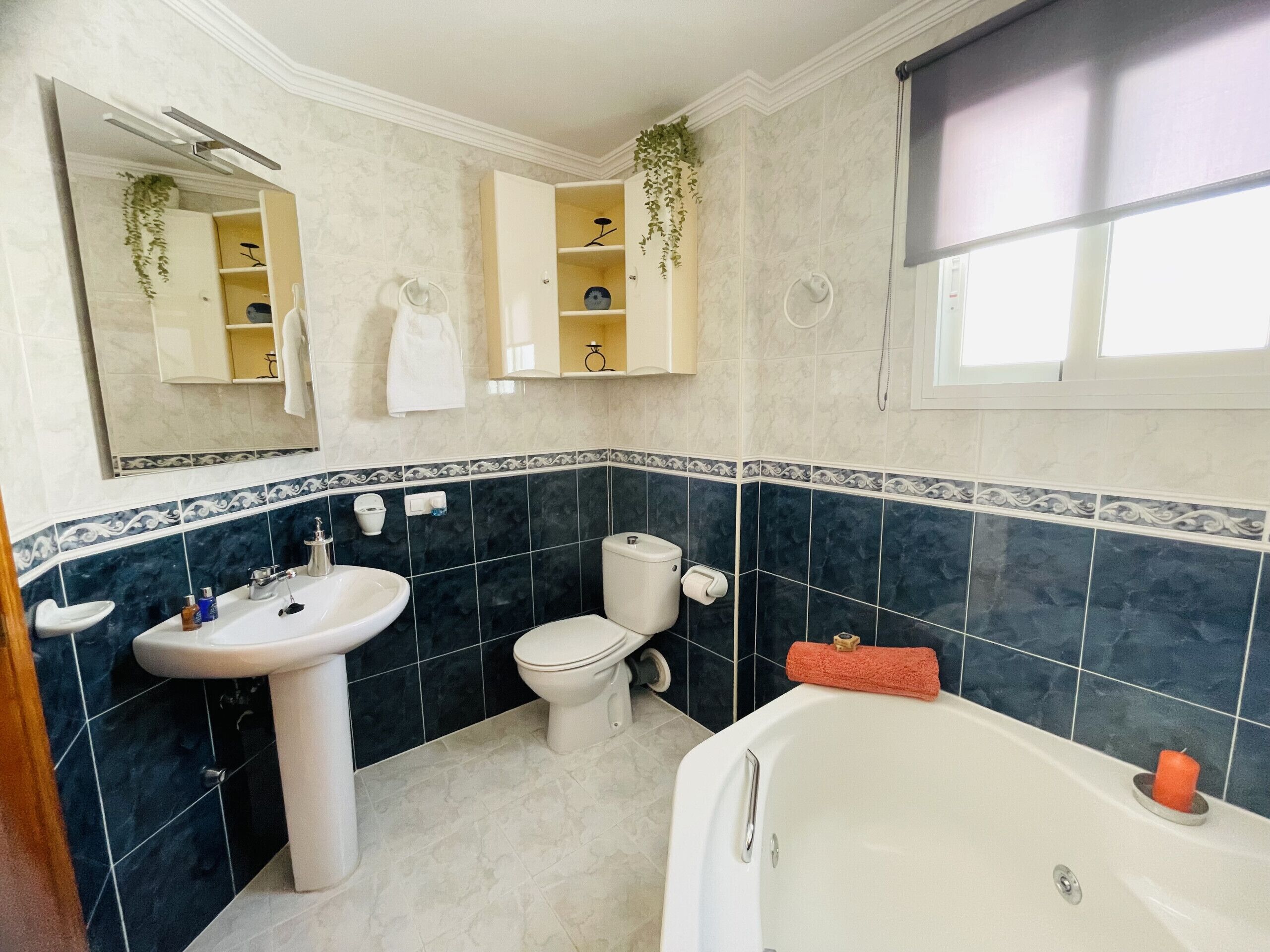 Een badkamer met een wastafel, toilet, bad en een spiegel.